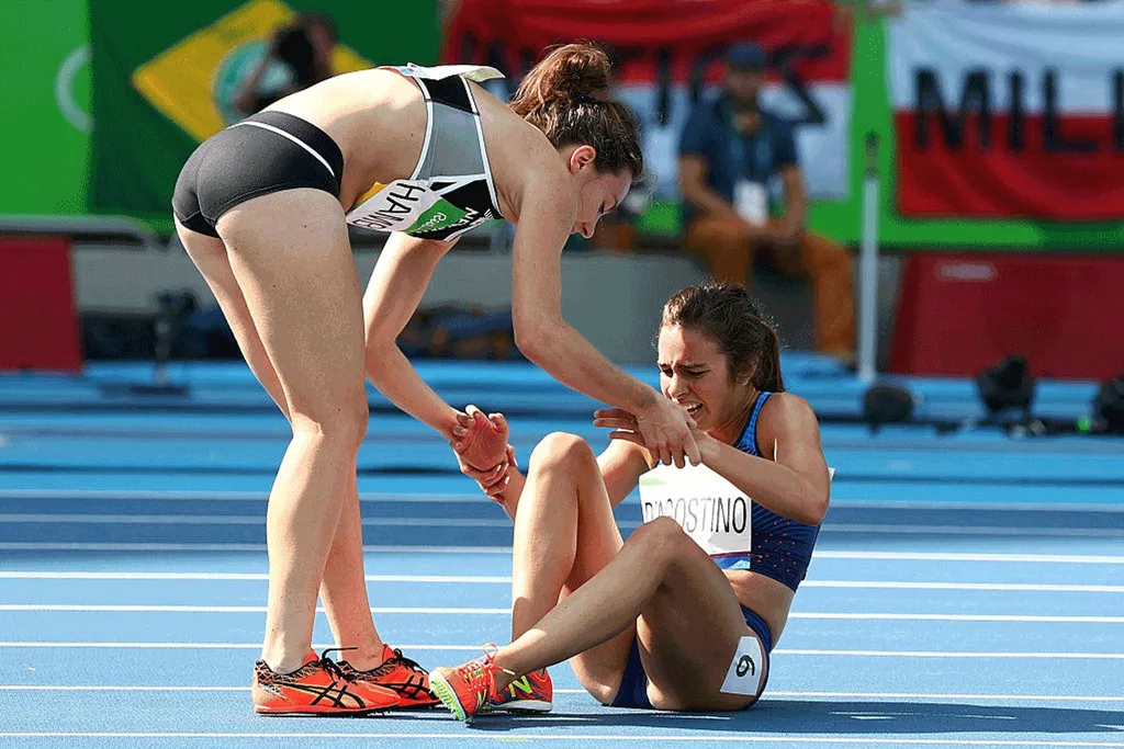 Hamblin helping D'Agostino to her feet.