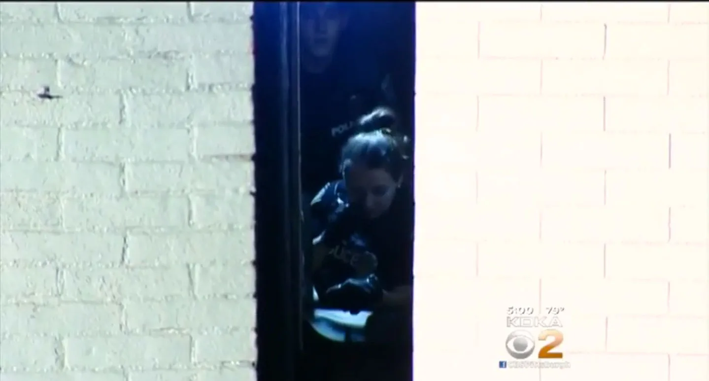 Police officer checks on the man between the buildings