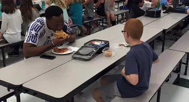 US Football player shares heartwarming lunch with middle school student eating alone