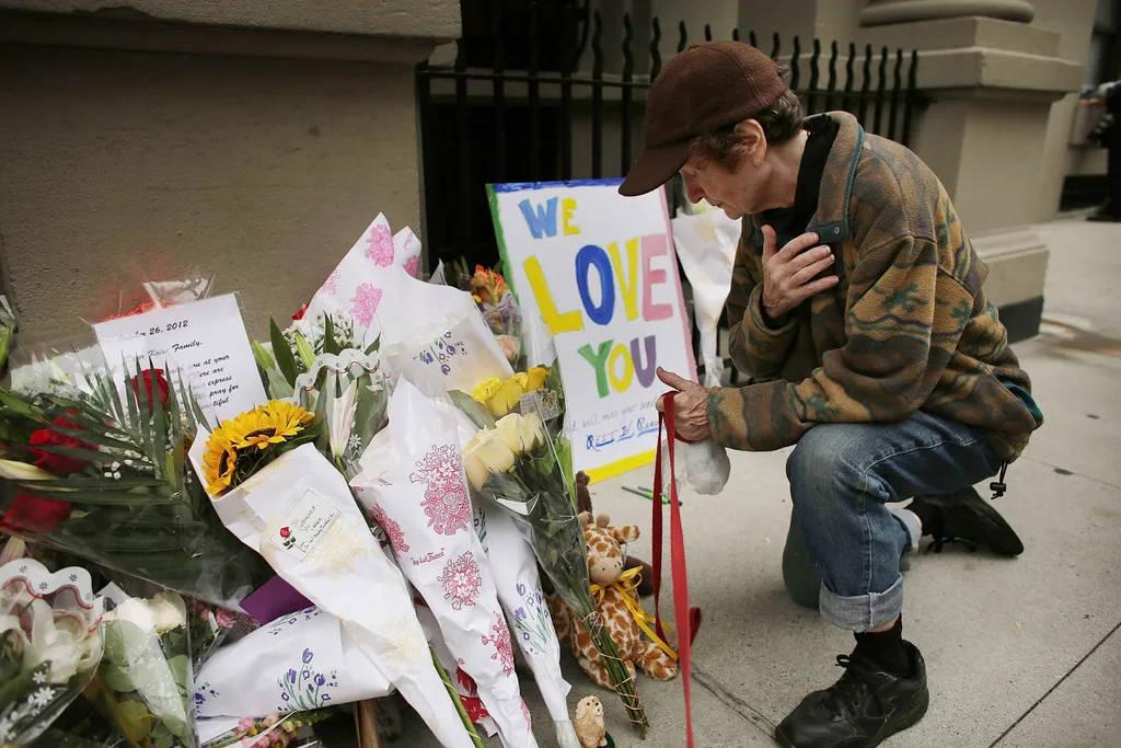 Mourner pays respects outside apartment building where Yoselyn Ortega allegedly stabbed two children to death.