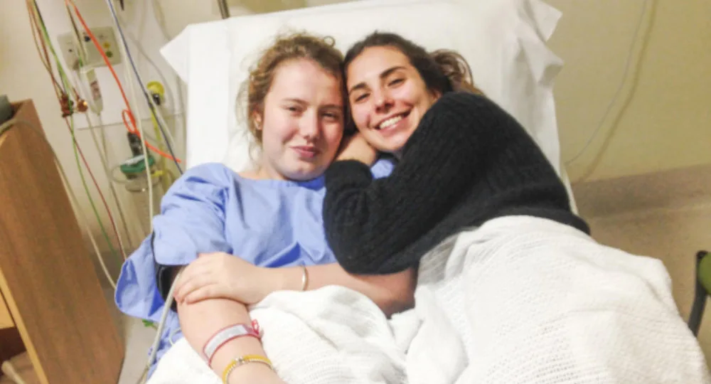 Grace Corcoran in hospital being treated while her friend Lily visits
