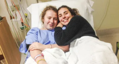 Grace Corcoran in hospital being treated while her friend Lily visits