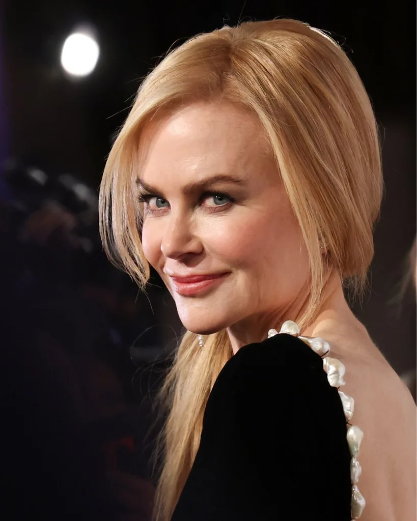 celebrity gemini nicole kidman smiles over her shoulder wearing a backless black dress