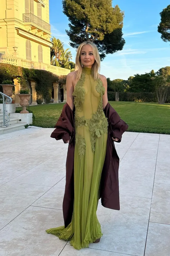 Nicole Richie in a green sheer wedding guest dress outside in a courtyard