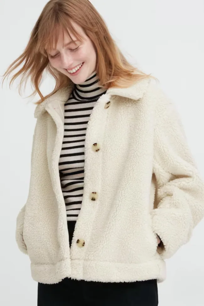 A model wearing the UNIQLO white sherpa fleece jacket.