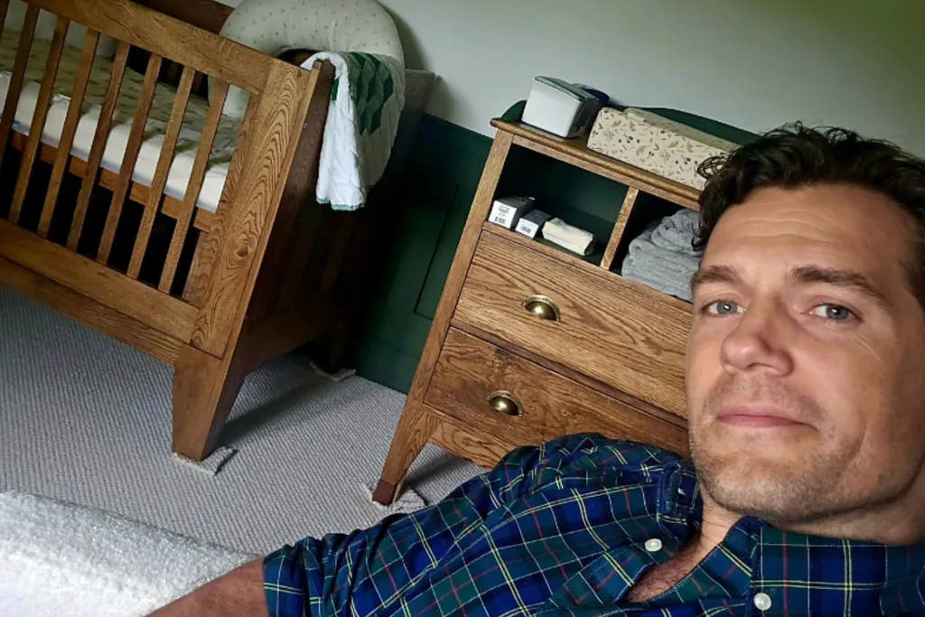 Henry Cavill sitting in a children's nursery.