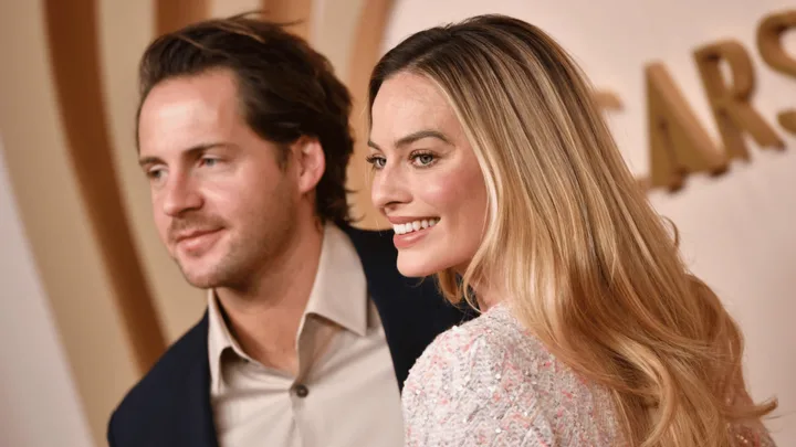 Margot Robbie and Tom Ackerley looking happy on red carpet
