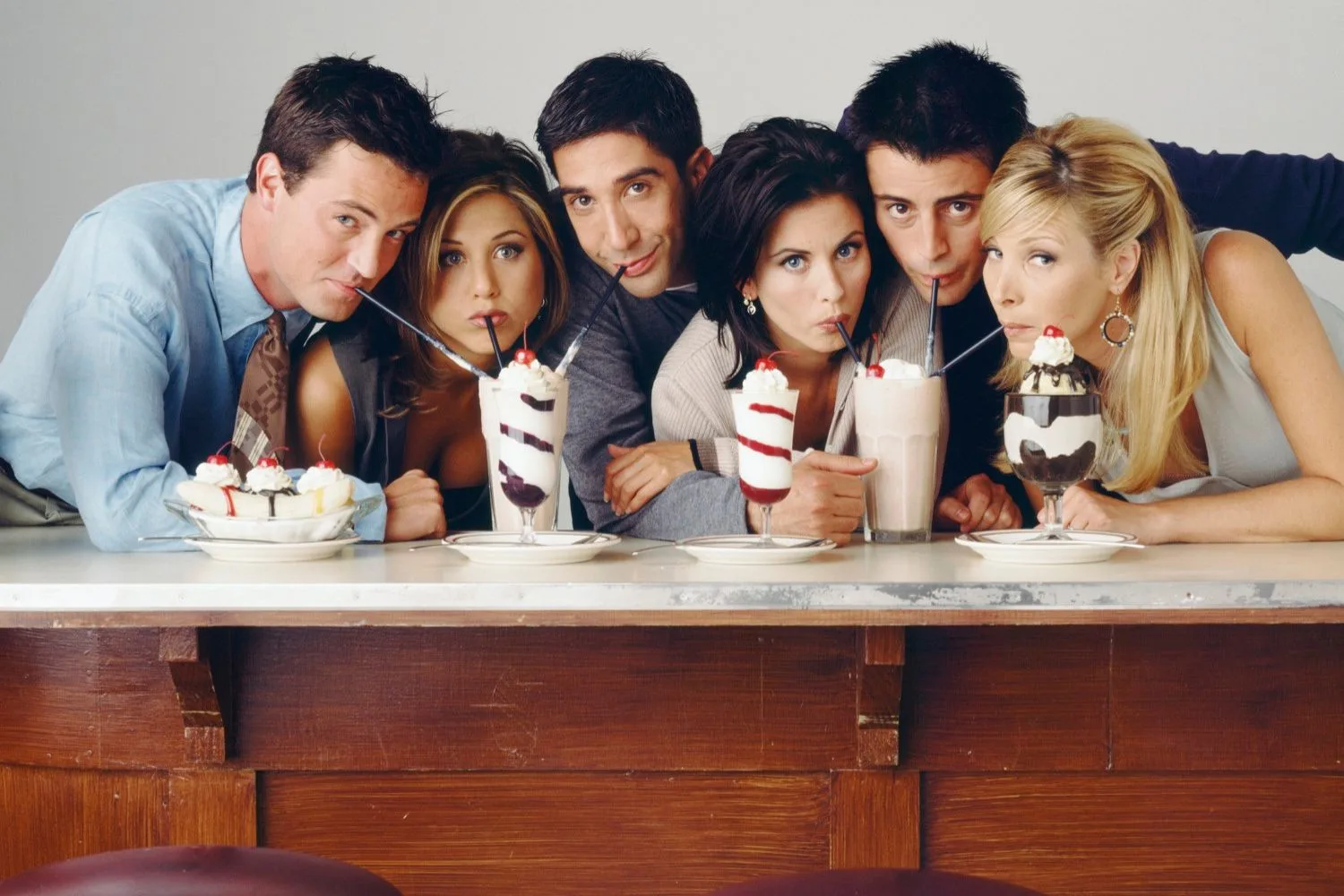 The cast of Friends drinking milkshakes in photoshoot.