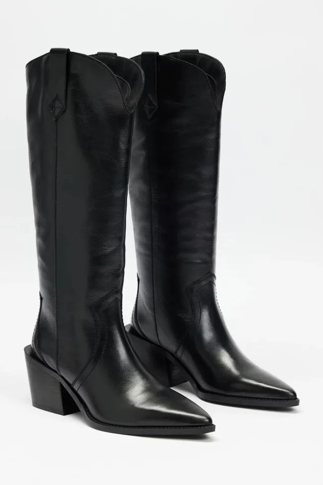Black leather cowboy boots with block heels and pointed toes on a plain background.