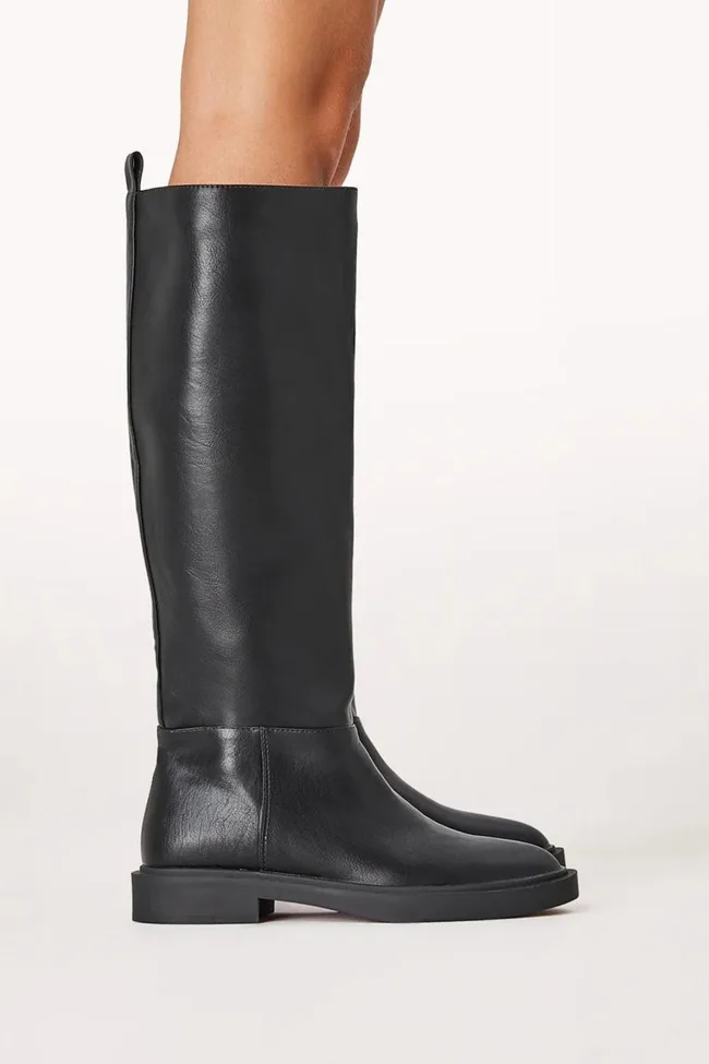 Black knee-high leather boots worn by a person, side view on a light background.