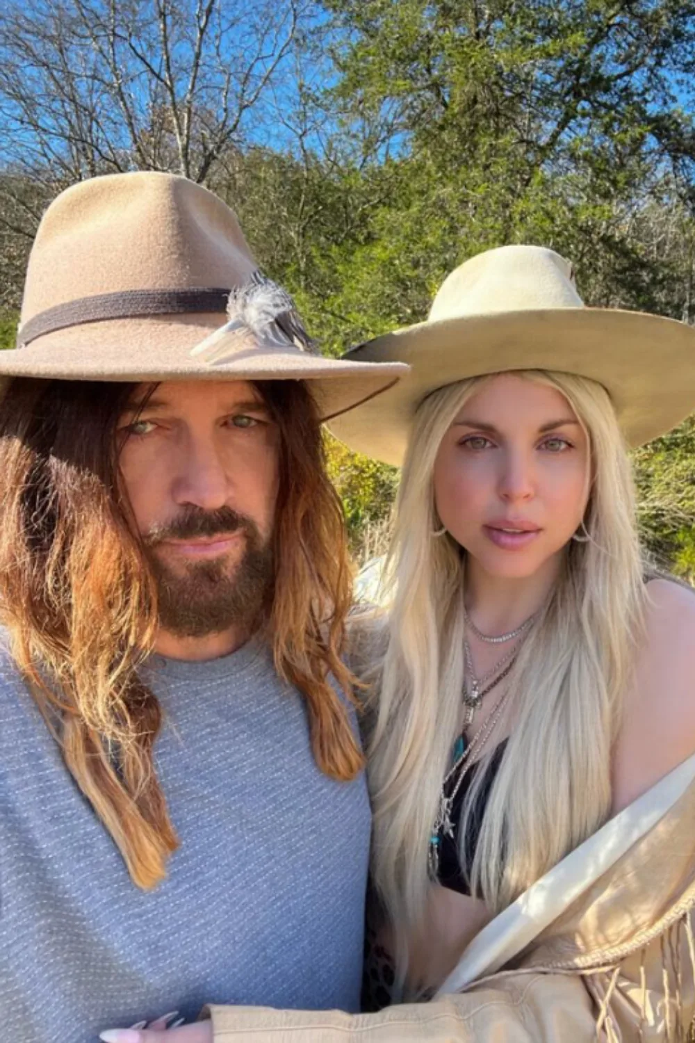 Billy Ray Cyrus and Firerose standing outside.