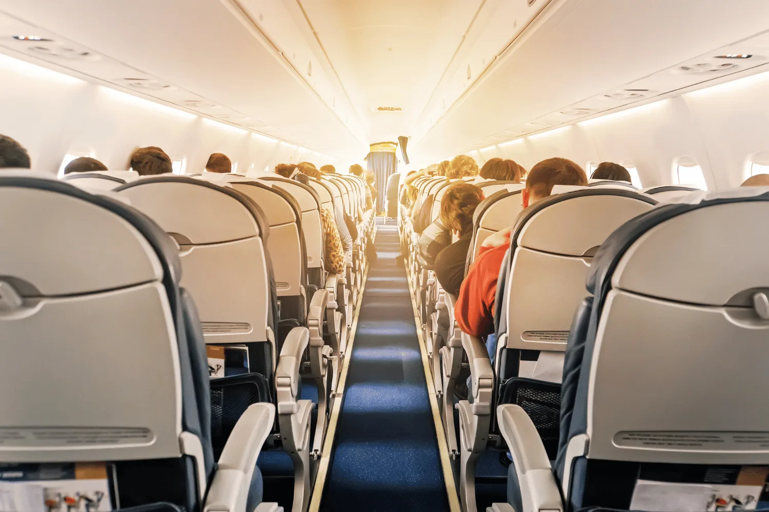 Interior shot of plane seats and isle.