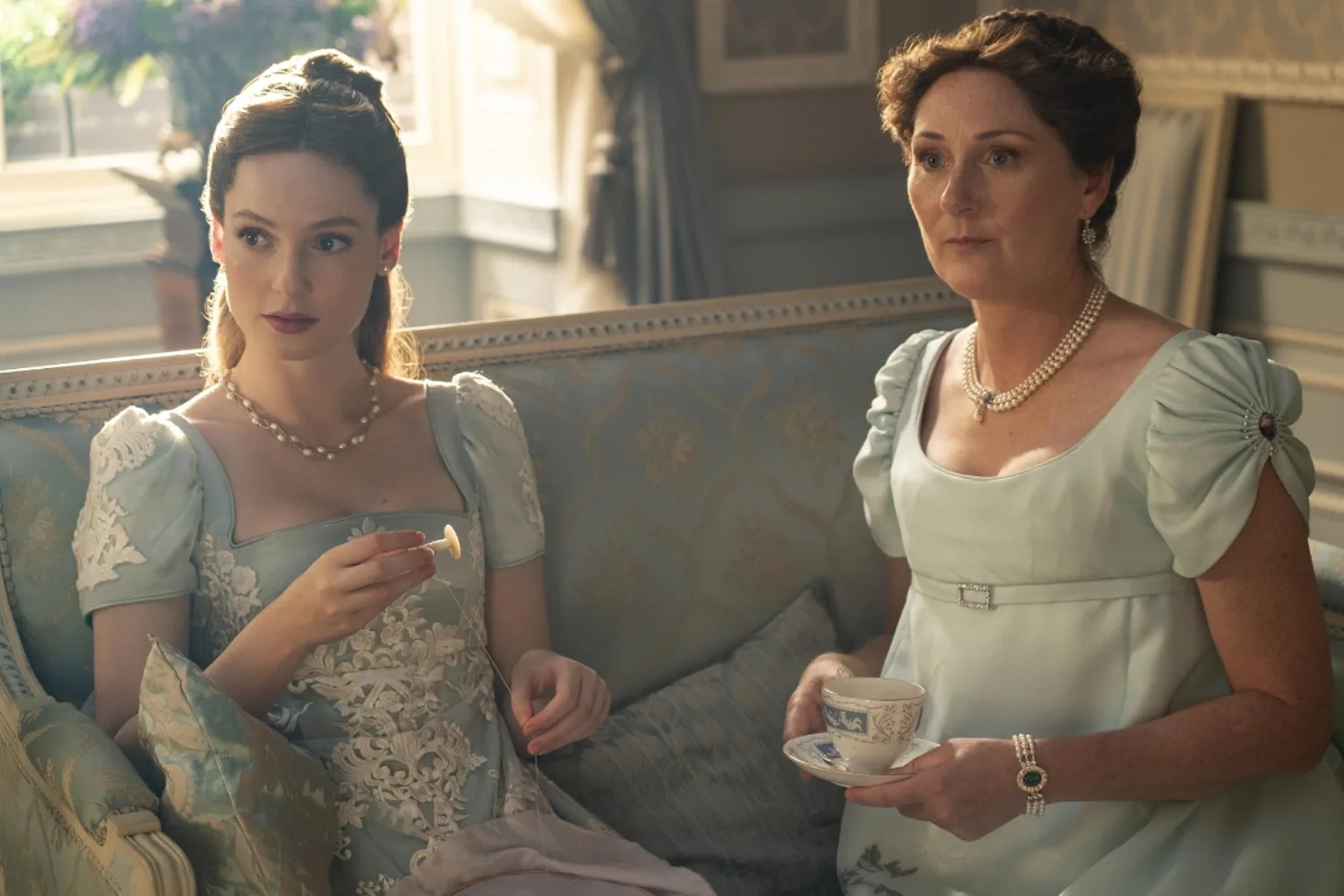Francesca Bridgerton and Violet Bridgerton sitting together on a couch.