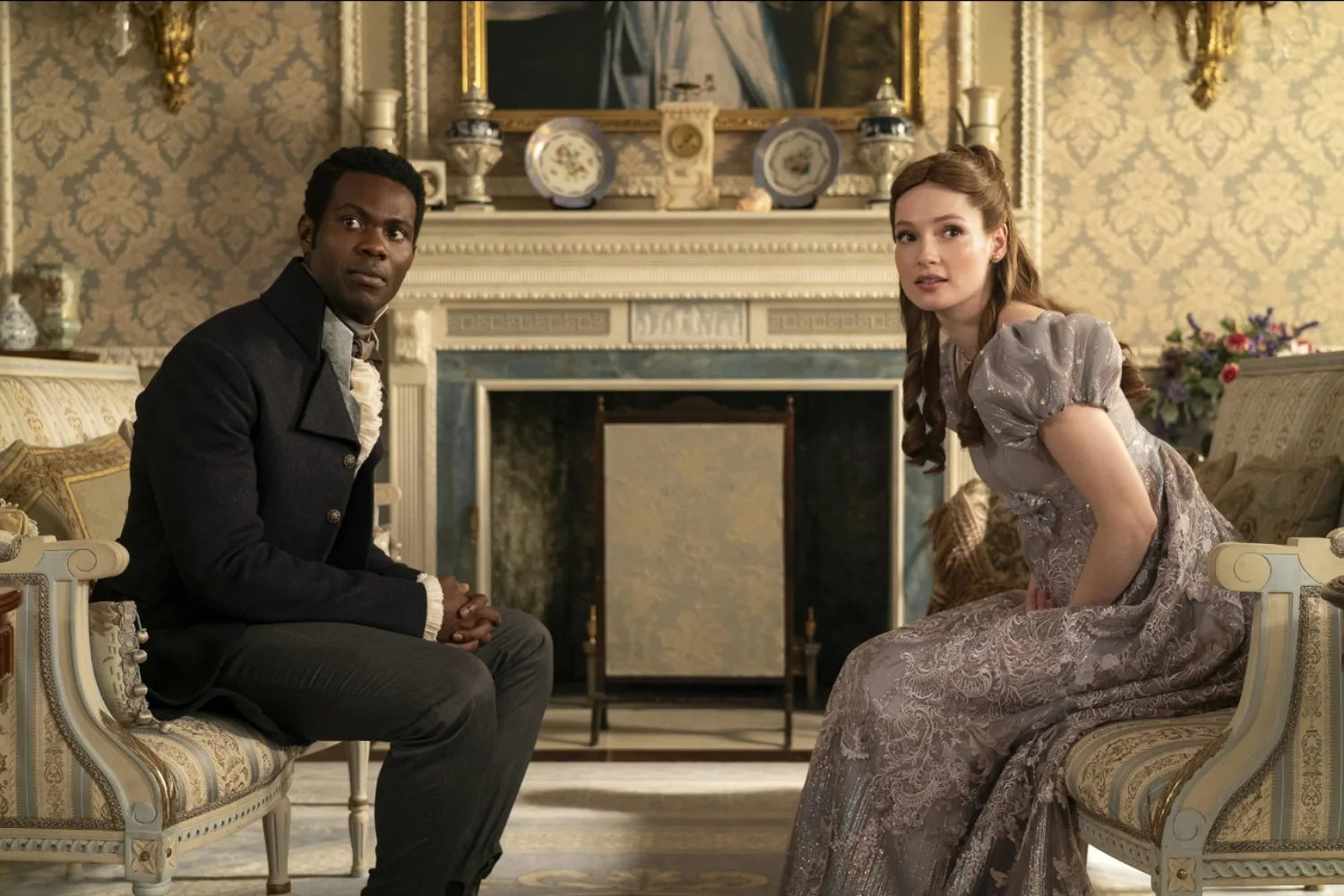 Bridgerton characters John Stirling and Francesca Bridgerton sitting across from one another.