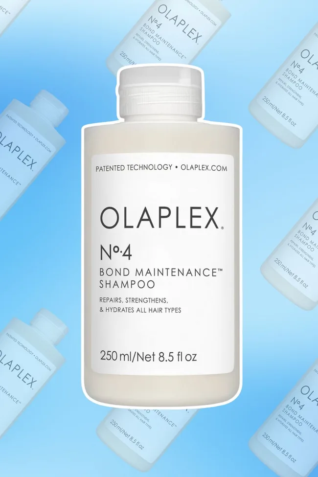 Bottle of Olaplex No. 4 Bond Maintenance Shampoo against a blue background.