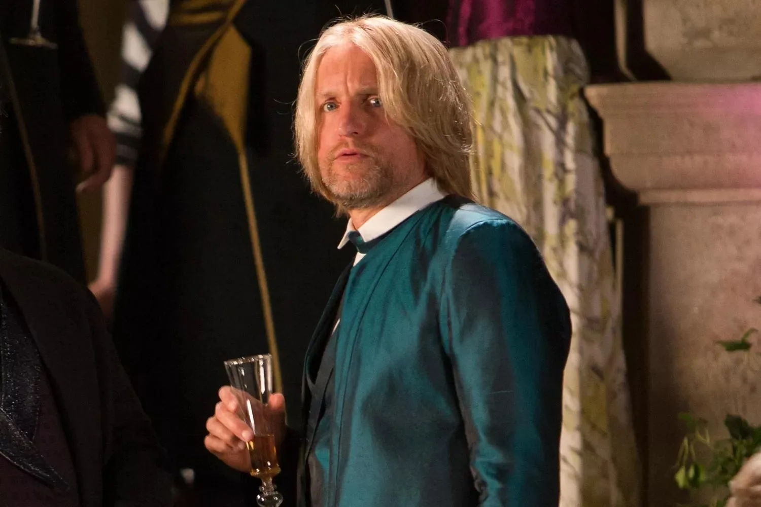 Woody Harrelson wearing a green suit as Haymitch Abernathy in The Hunger Games.