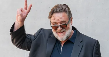 Russell Crowe giving the peace sign and smiling