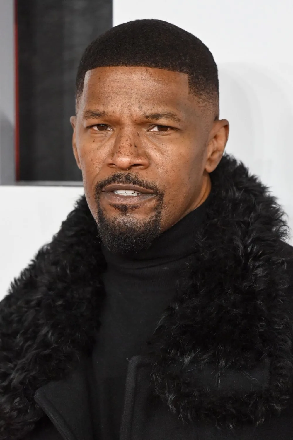 Jamie Foxx in black fur coat.