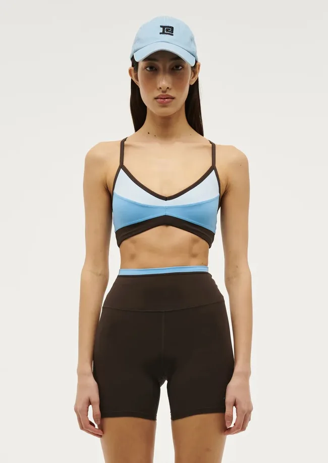 A model wearing the Overland 2 Sports Bra in Bright Blue
