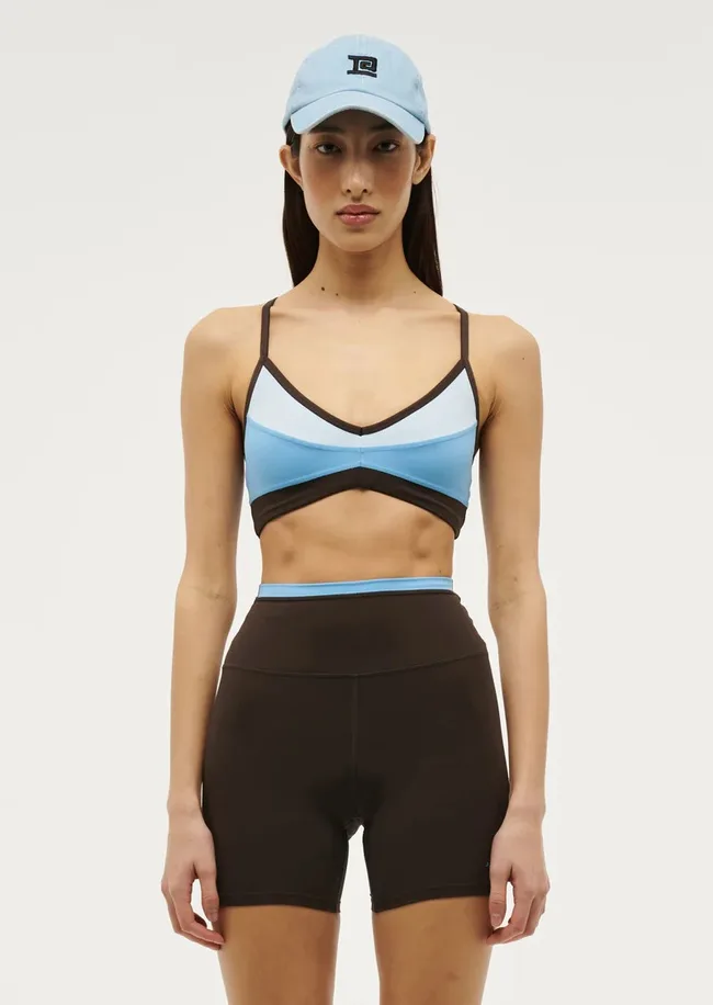 A model wearing the Overland 2 Sports Bra in Bright Blue