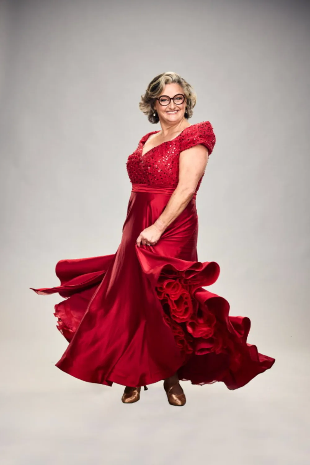 Julie Goodwin twirling in a red dress.