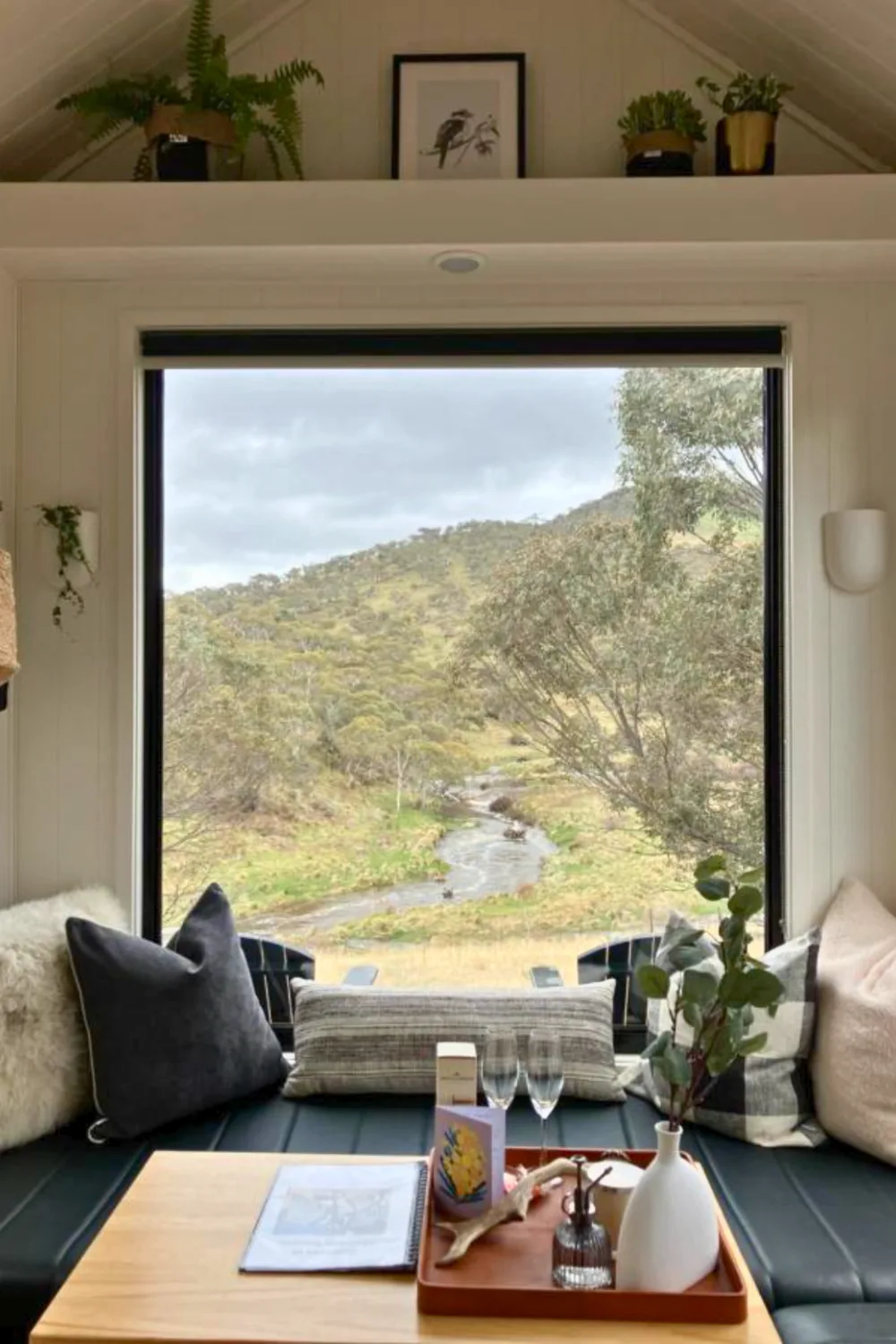 Tiny house window with view of stream.