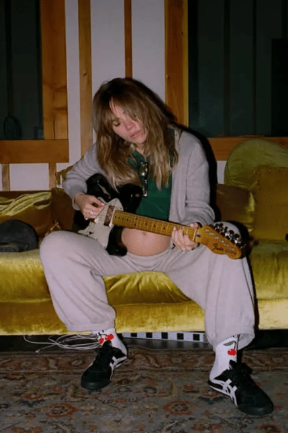 Suki Waterhouse pregnant holding a guitar