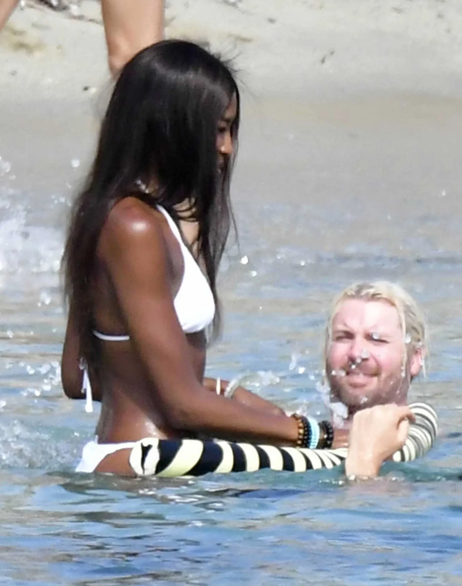 Naomi Campbell stands waist-deep in water with DJ Rampa in Mykonos.