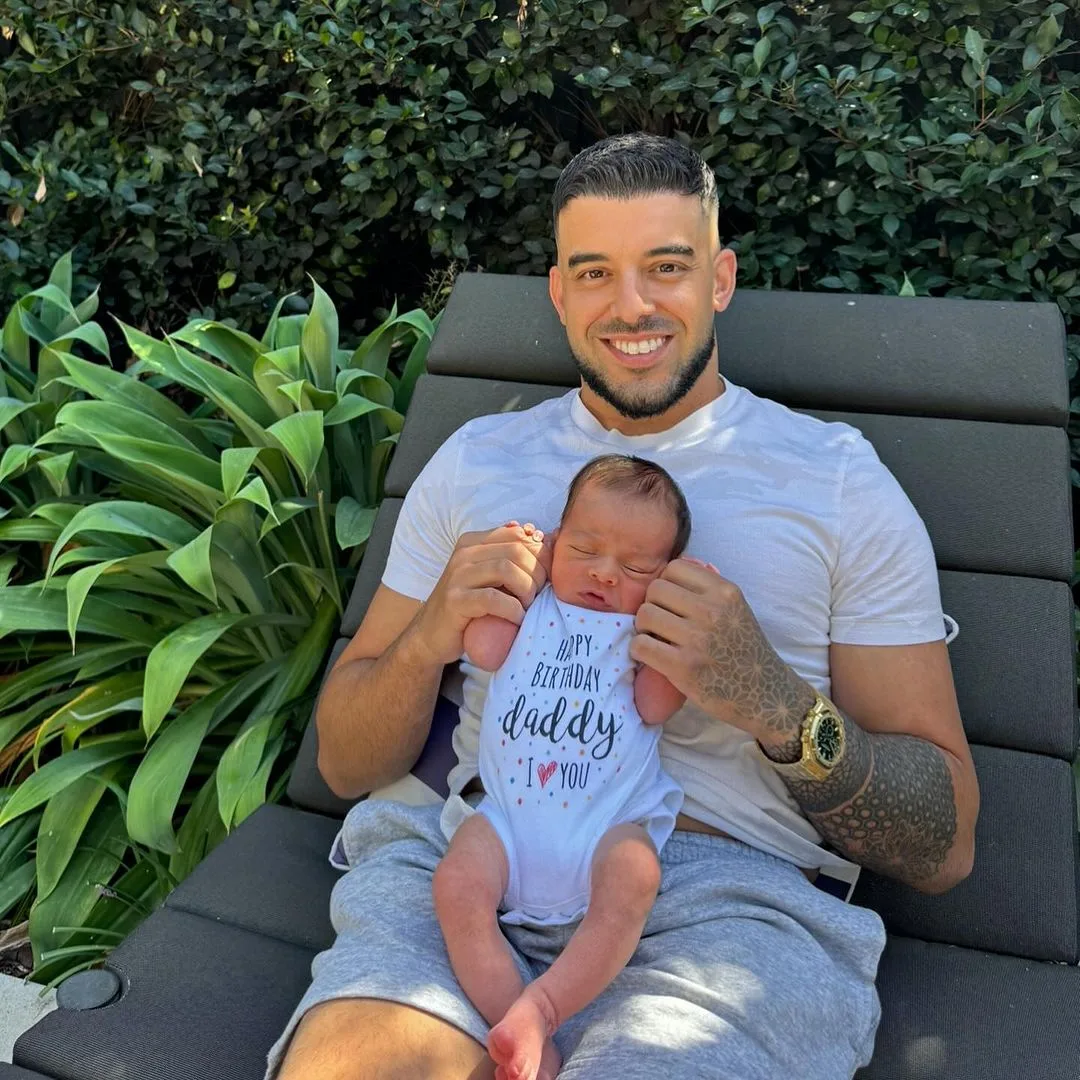 Adrian Portelli cuddling his son