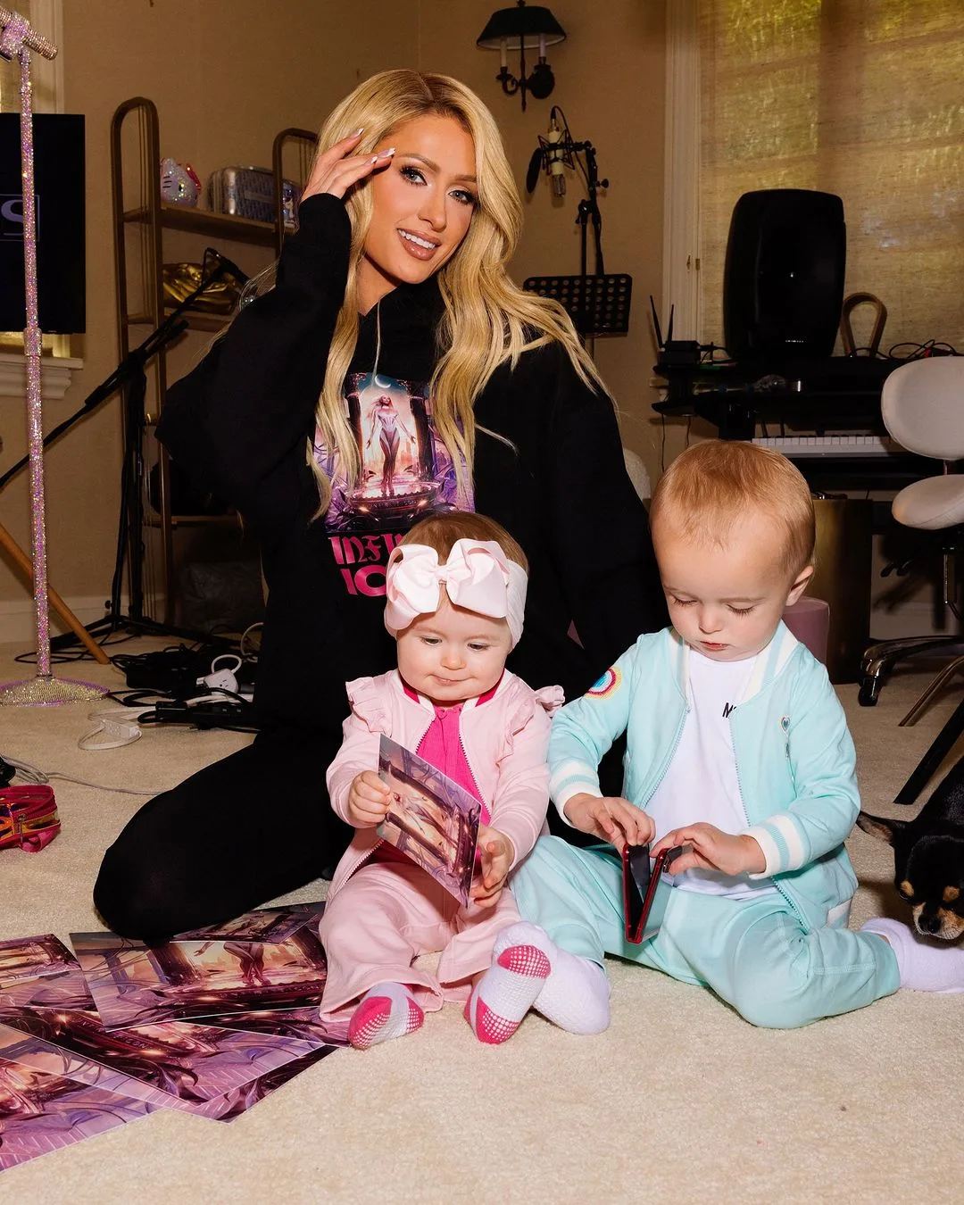 Paris Hilton sitting on the floor with London and Phoenix