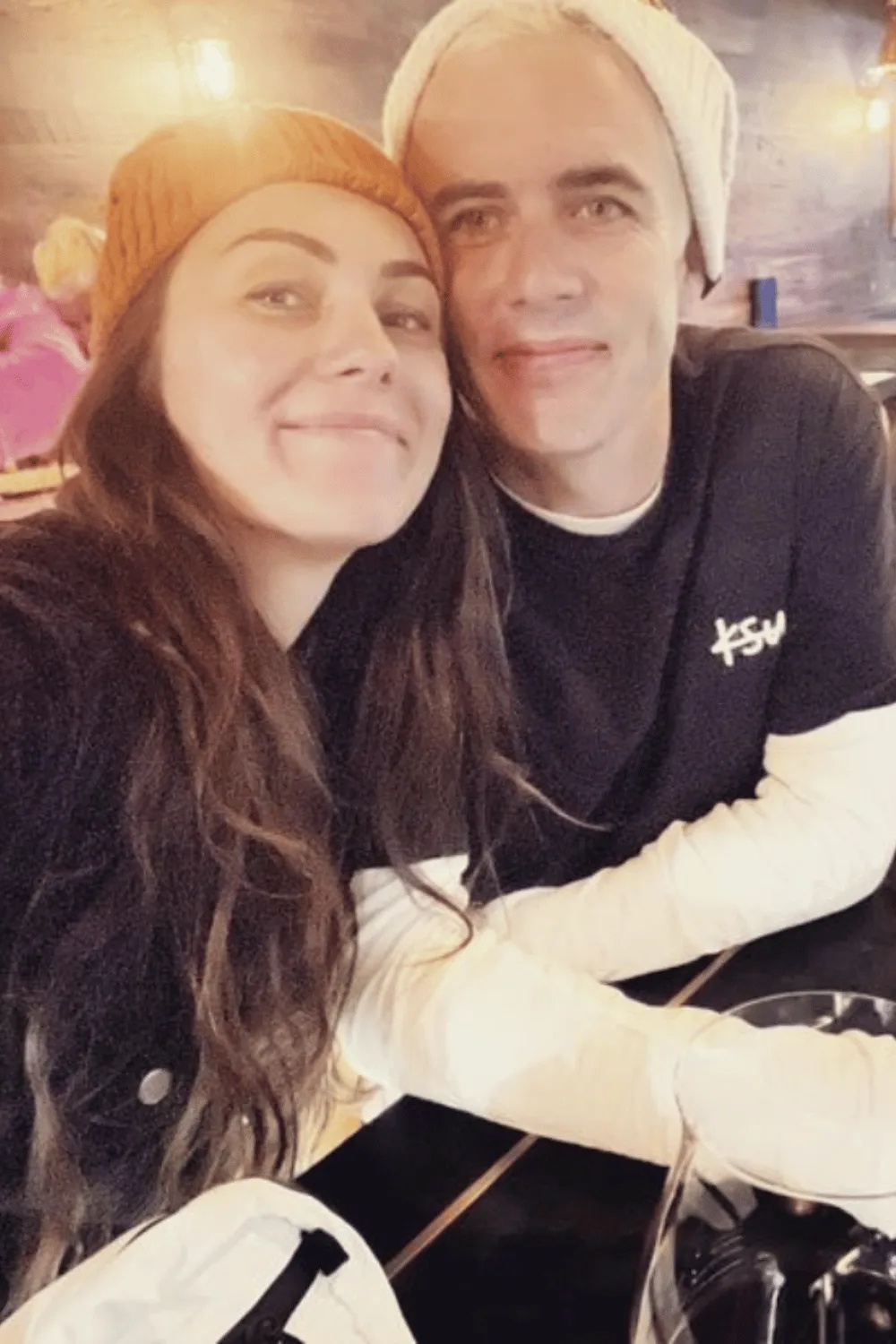 Amy Shark sitting at a dinner table next to husband Shane. 