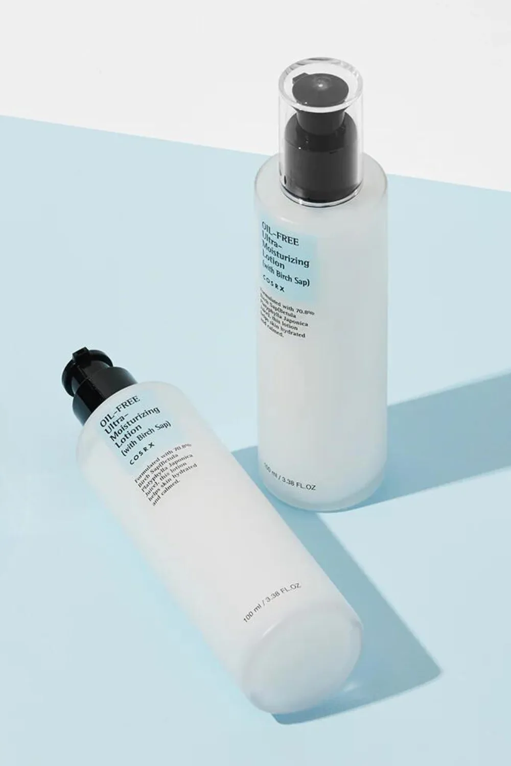 Two COSRX oil-free moisturising lotions on a blue backdrop.