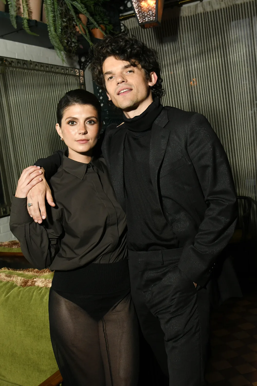 Edward Bluemel standing with his arm around Emily Bader.