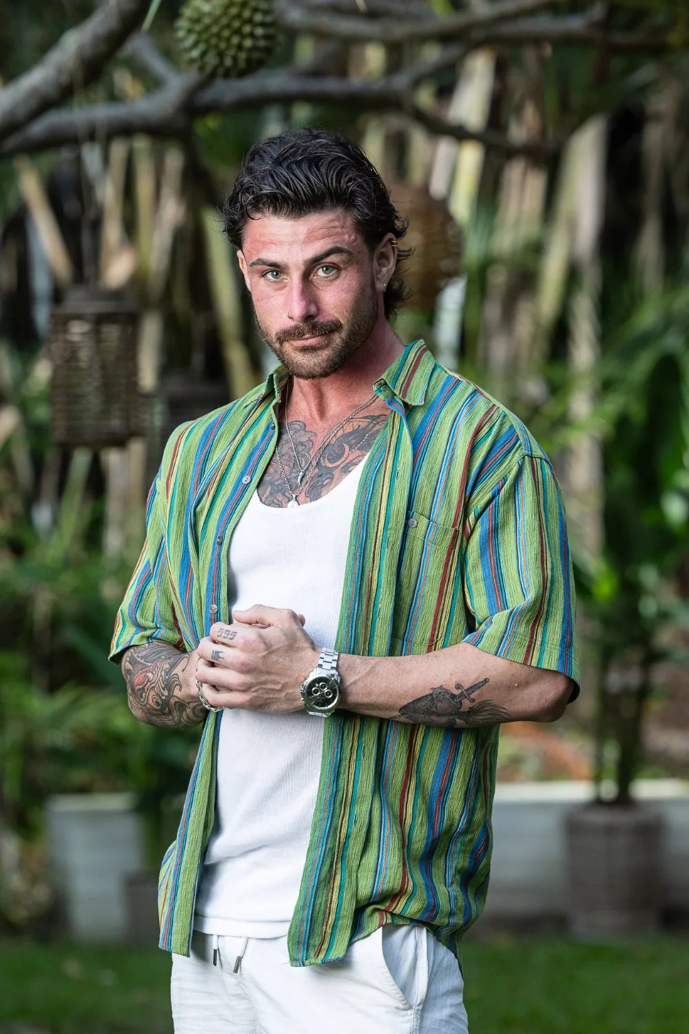 Jake from FBoy Island Australia standing in front of a jungle background. 