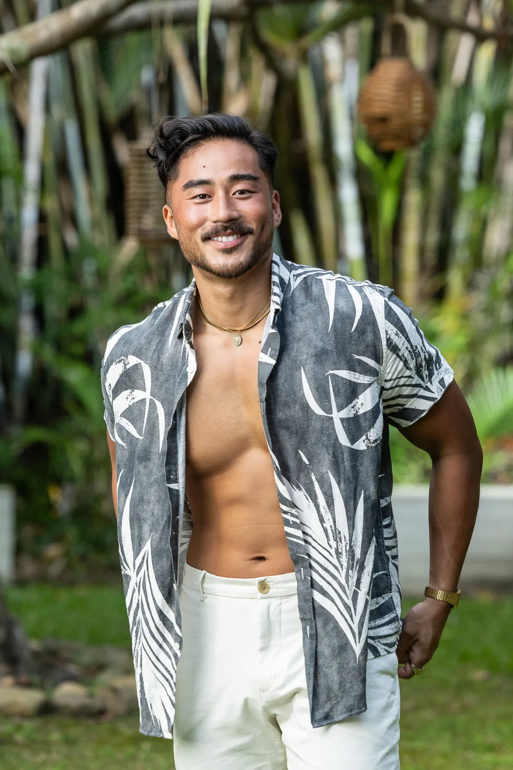 Jin from FBoy Island Australia standing in front of a jungle backdrop. 