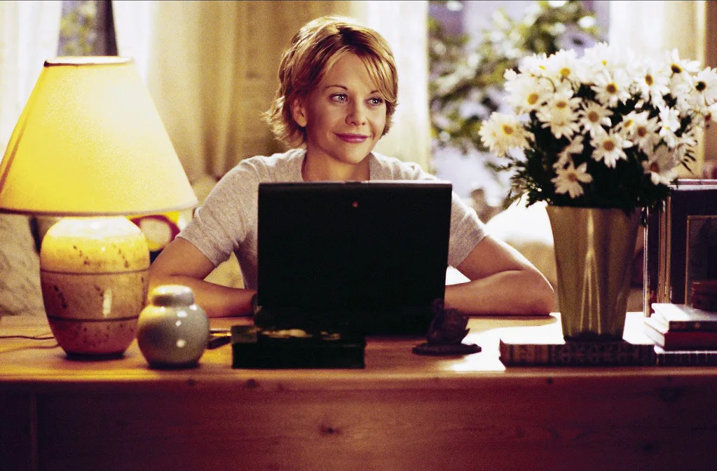 Meg Ryan smiling with laptop in You've Got Mail