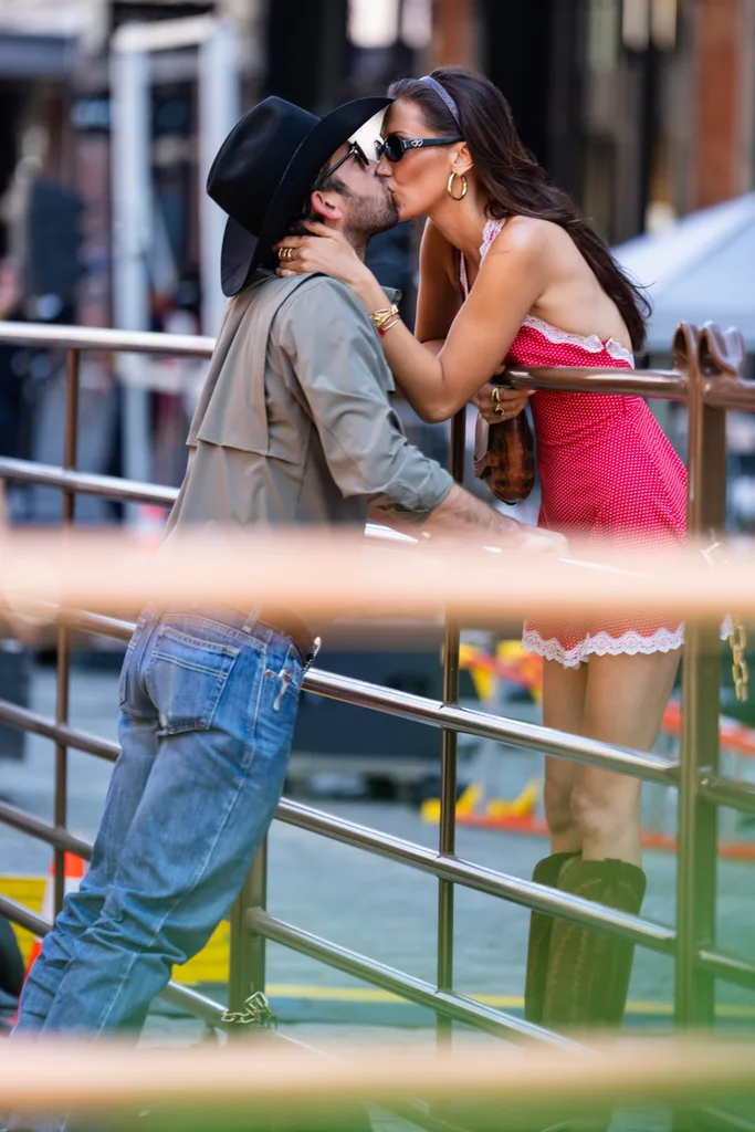 Bella Hadid kissing new beau Adan Banuelos over a fence.