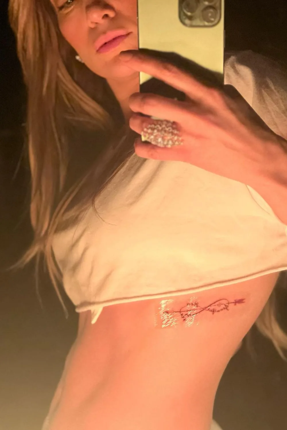 Jennifer Lopez in a crop top exposing ribcage infinity tattoo