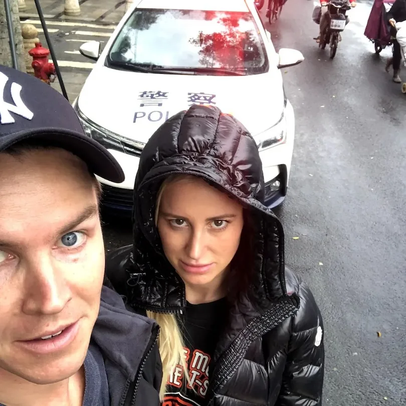 Selfie of Jacenko and Curtis in front of a police car