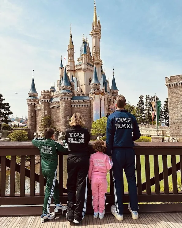 The Blake family at Disney in Japan facing away from camera to show off matching Blake tracksuits.