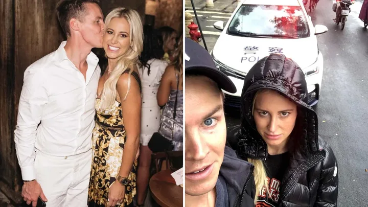 Jacenko and Curtis kissing and photographed in front of a police car