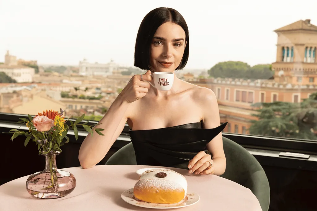 Lily Collins holding an espresso cup with the writing 'Emily in Paris.'