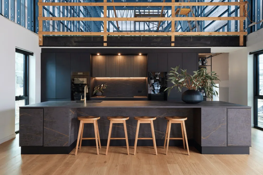 A dark black wood kitchen with four light wood stools under the benchtop.