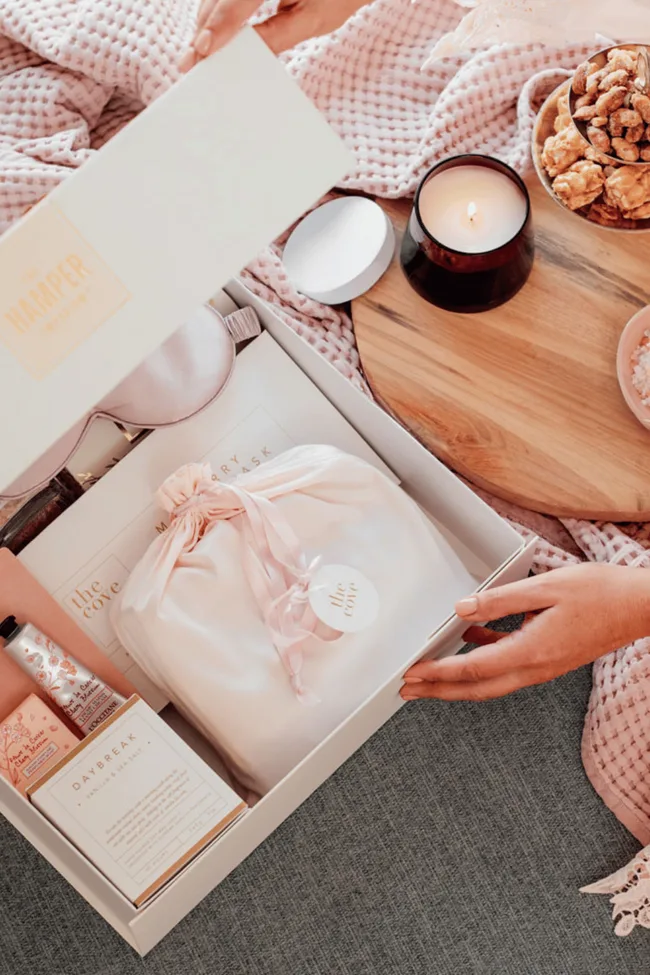 A pink coloured hamper box filled with skincare.