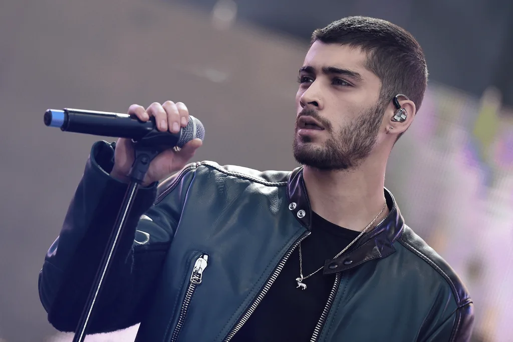 Zayn Malik on stage holding a microphone stand