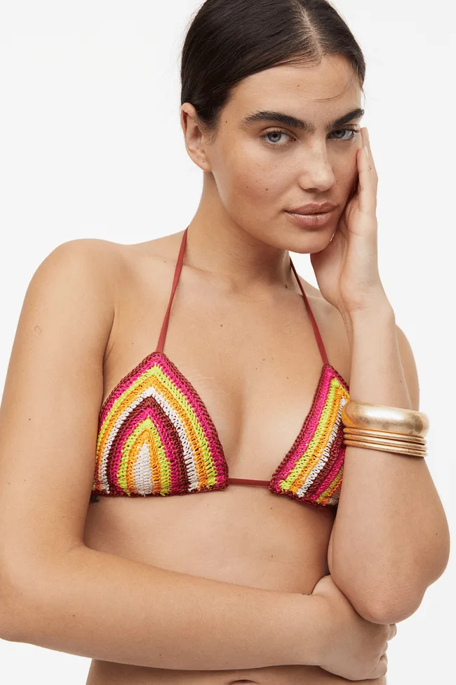 A model wearing a multi-coloured crochet bikini top.