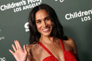 Meghan Markle waving to the camera from the red carpet