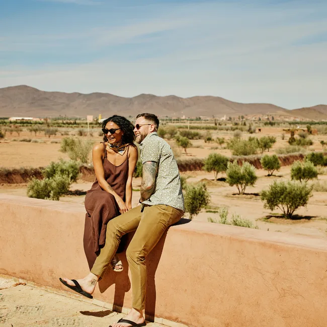 A couple taking a photo at a beautiful destination, enjoying their Black Friday travel package deal.