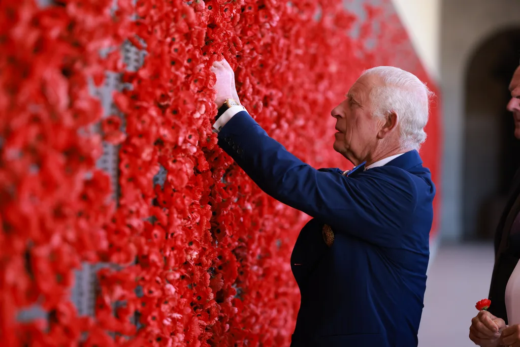 King Charles places a poppy on the wall at the Australian War Memorial.