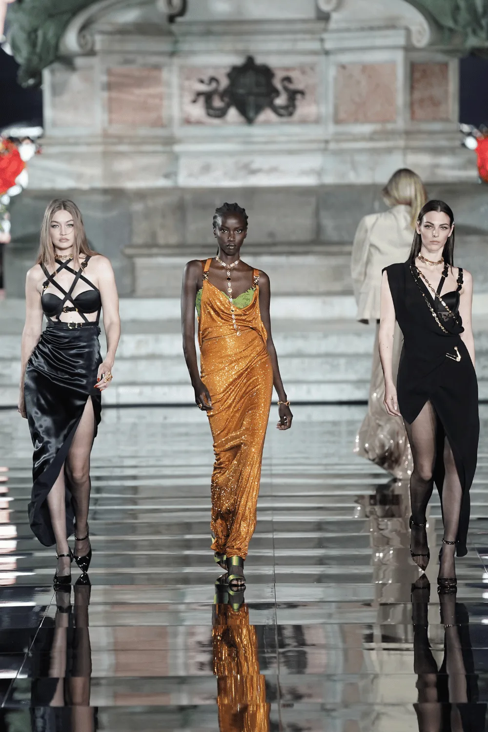 Gigi Hadid, Anok Yai, and Vittoria Ceretti walking a runway. 